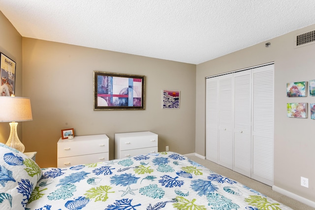 bedroom with carpet floors, a closet, and a textured ceiling