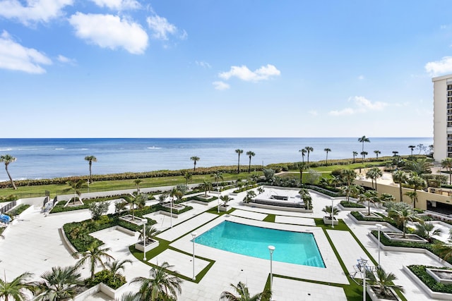 view of swimming pool with a patio and a water view