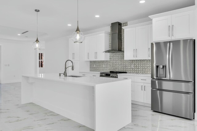 kitchen featuring pendant lighting, wall chimney range hood, a kitchen island with sink, stainless steel refrigerator with ice dispenser, and white cabinets