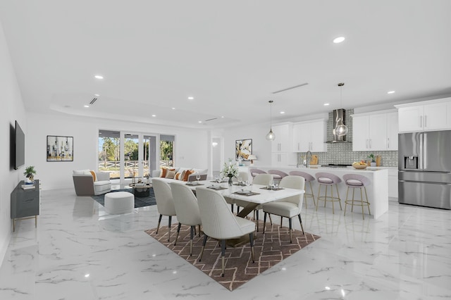 dining space with sink and a tray ceiling