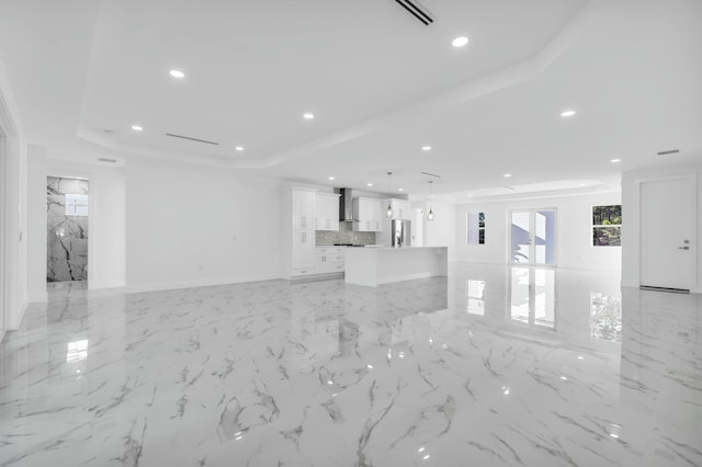 unfurnished living room featuring a tray ceiling