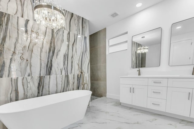 bathroom featuring vanity, a washtub, and an inviting chandelier