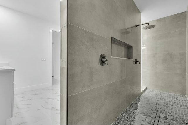 bathroom with tiled shower and vanity