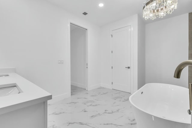 interior space with vanity, an inviting chandelier, and a bathtub