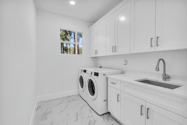 laundry area featuring cabinets, sink, and washing machine and clothes dryer