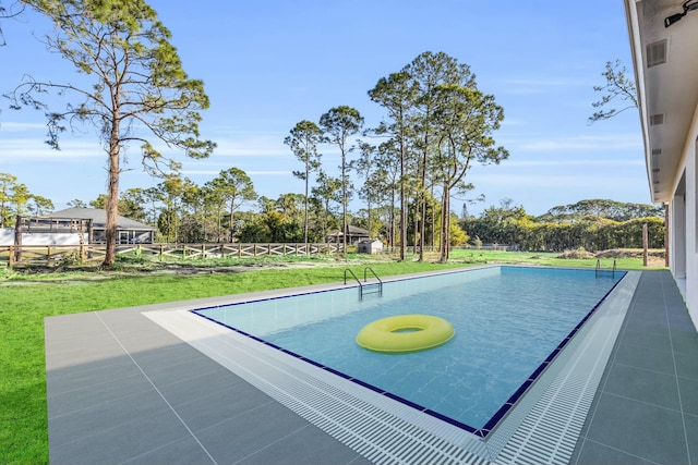 view of pool featuring a lawn