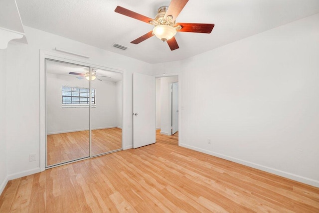 unfurnished bedroom with ceiling fan, a closet, and light hardwood / wood-style flooring