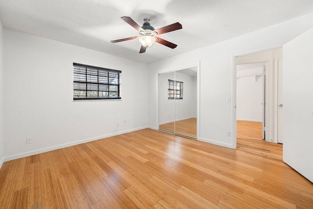 unfurnished bedroom with hardwood / wood-style flooring, a textured ceiling, and ceiling fan