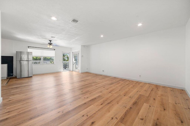 unfurnished living room featuring a textured ceiling, ceiling fan, and light wood-type flooring