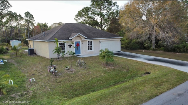 view of front of house featuring a garage, central AC unit, and a front lawn