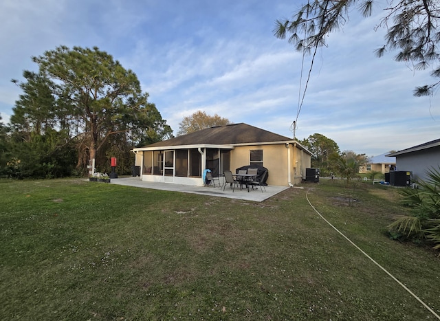 back of house featuring a patio, a sunroom, a yard, and central AC unit