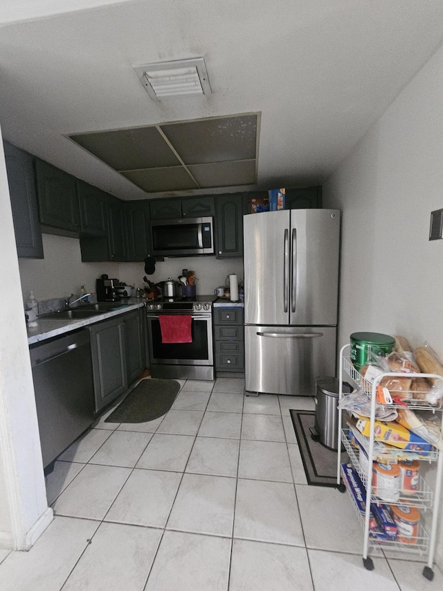 kitchen with stainless steel appliances, sink, and light tile patterned floors