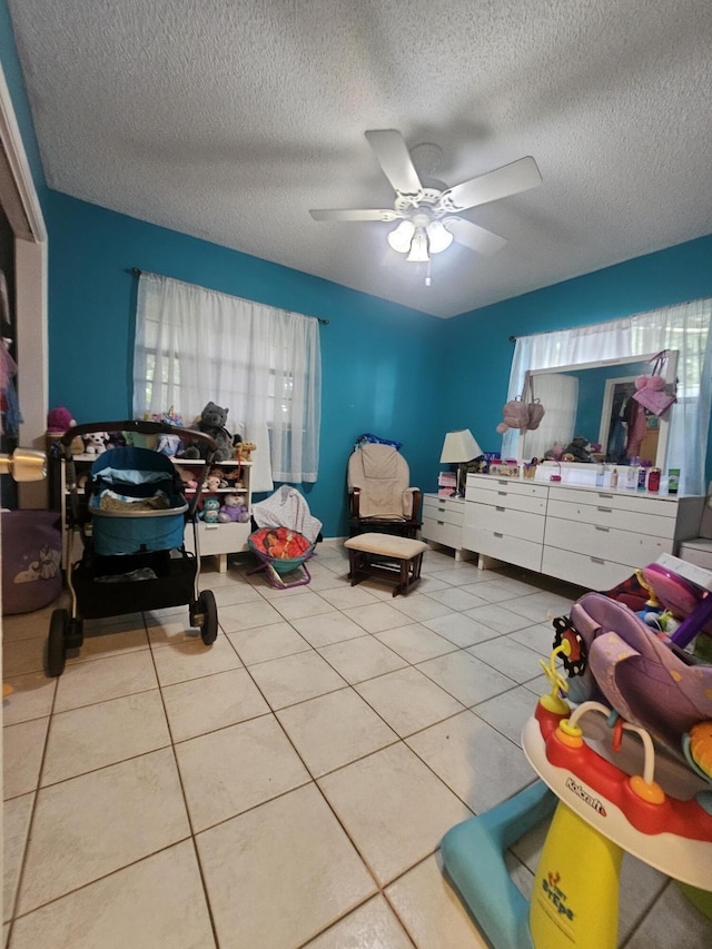 bedroom with light tile patterned floors, a textured ceiling, and ceiling fan