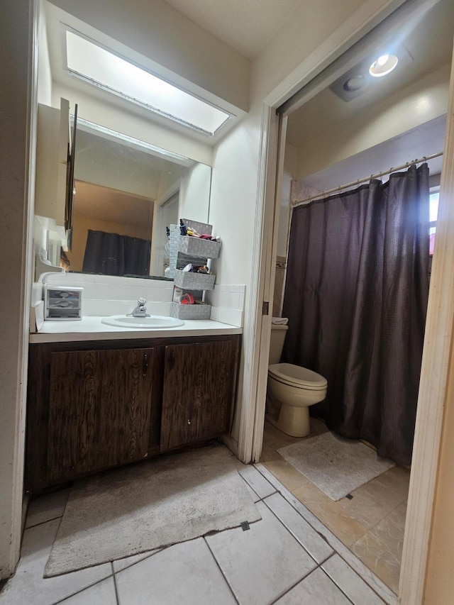 bathroom with vanity, a skylight, and toilet