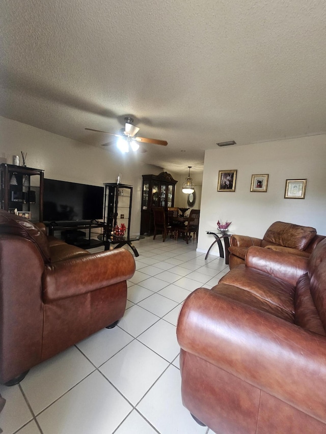 tiled living room with a textured ceiling and ceiling fan