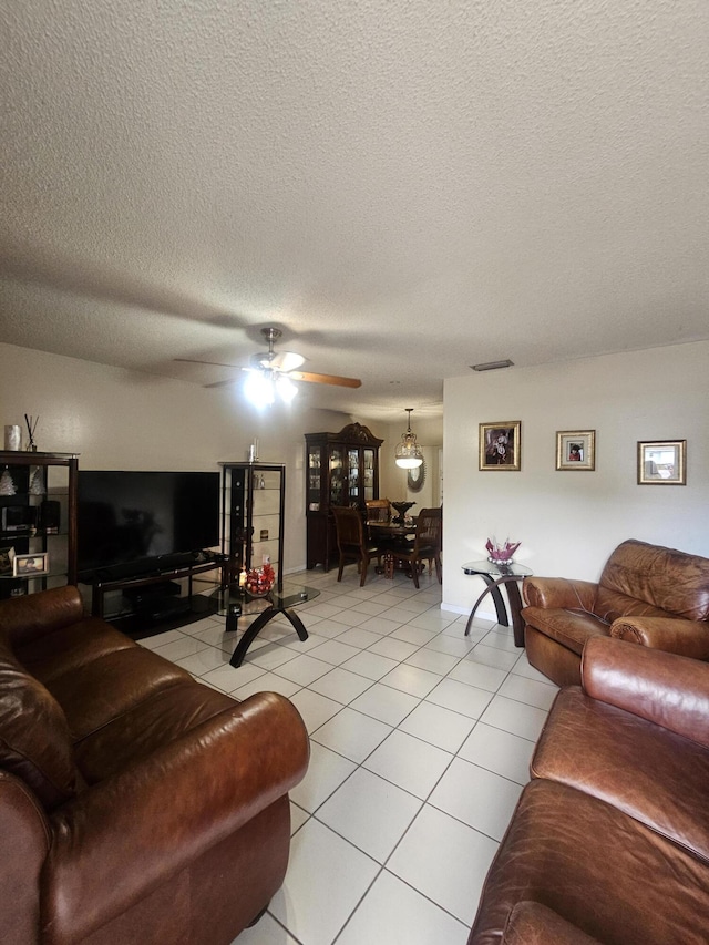 tiled living room with ceiling fan and a textured ceiling