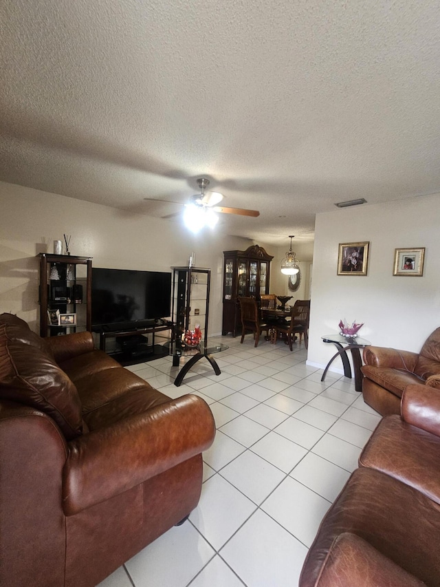 tiled living room featuring a textured ceiling and ceiling fan