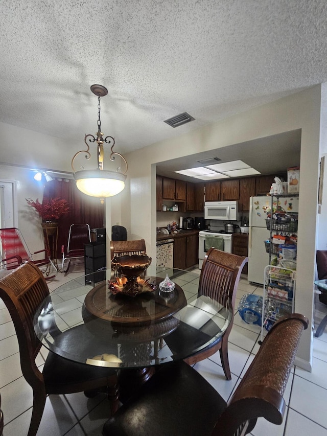 dining area with light tile patterned floors and a textured ceiling