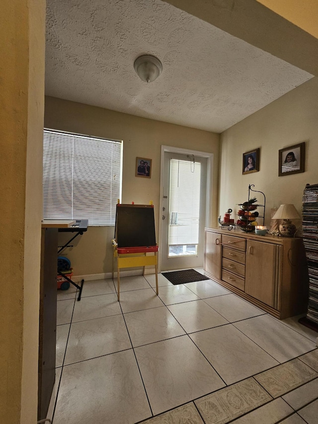 entrance foyer with light tile patterned floors and a textured ceiling