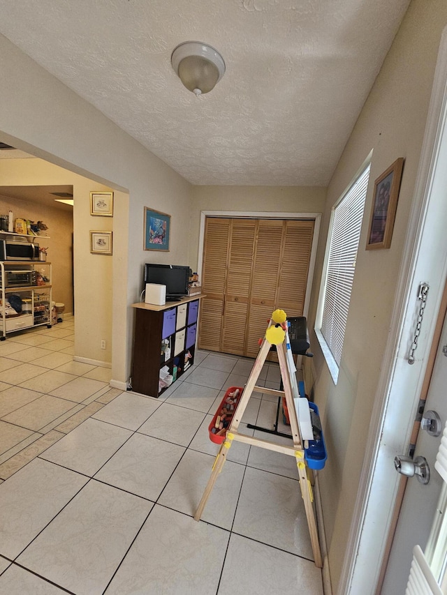 game room with tile patterned floors and a textured ceiling