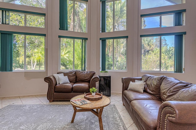 living room with light tile patterned floors, a healthy amount of sunlight, and a high ceiling