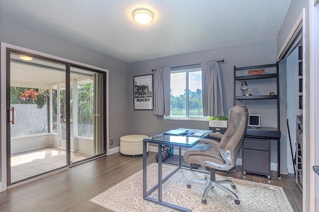 office with dark hardwood / wood-style floors and a textured ceiling