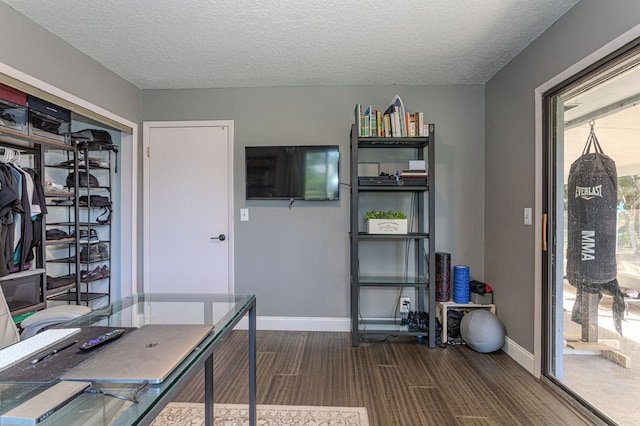 unfurnished office with hardwood / wood-style floors and a textured ceiling