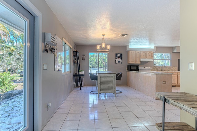 kitchen featuring light tile patterned flooring, a kitchen bar, light brown cabinetry, sink, and pendant lighting