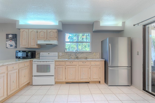 kitchen featuring sink, stainless steel fridge, electric range, a wealth of natural light, and light brown cabinets