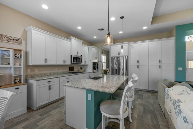 kitchen featuring appliances with stainless steel finishes, sink, pendant lighting, and white cabinets