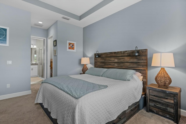 bedroom with light colored carpet and ensuite bath