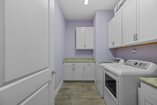 clothes washing area featuring cabinets and washer and dryer