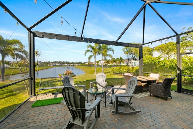 view of patio with glass enclosure and a water view