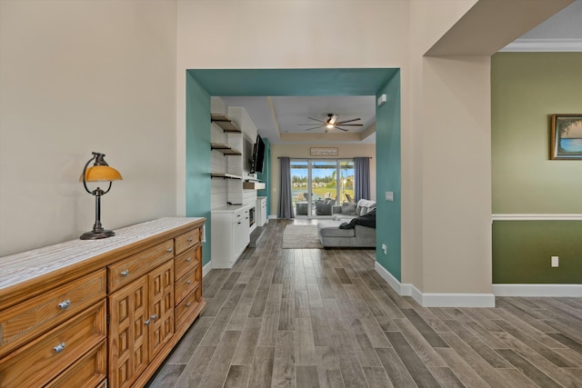 corridor featuring light hardwood / wood-style floors and a raised ceiling