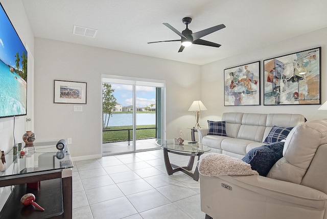 living room featuring a water view, ceiling fan, and light tile patterned floors