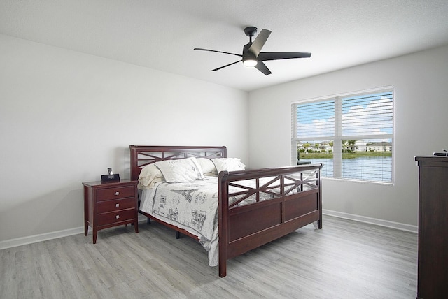 828 Persimmon Pl, Fort Pierce, FL 34981 - bedroom featuring light wood-type flooring, baseboards, a water view, and a ceiling fan