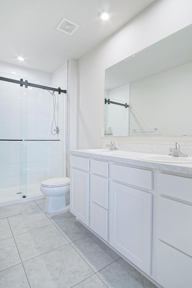 bathroom with vanity, toilet, and a shower with door