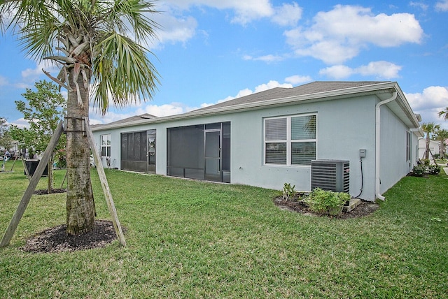 828 Persimmon Pl, Fort Pierce, FL 34981 - rear view of property featuring a sunroom, a yard, stucco siding, and cooling unit