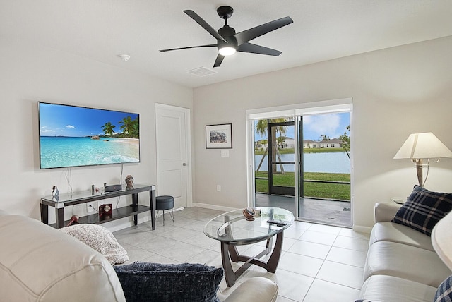 tiled living room with a water view and ceiling fan