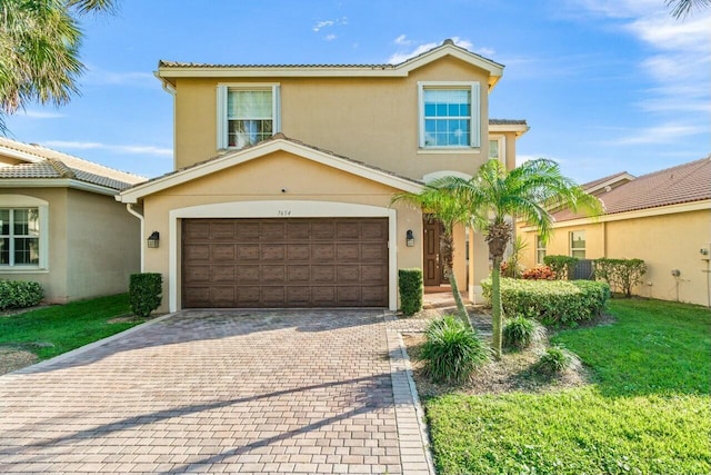 mediterranean / spanish house with a garage and a front yard