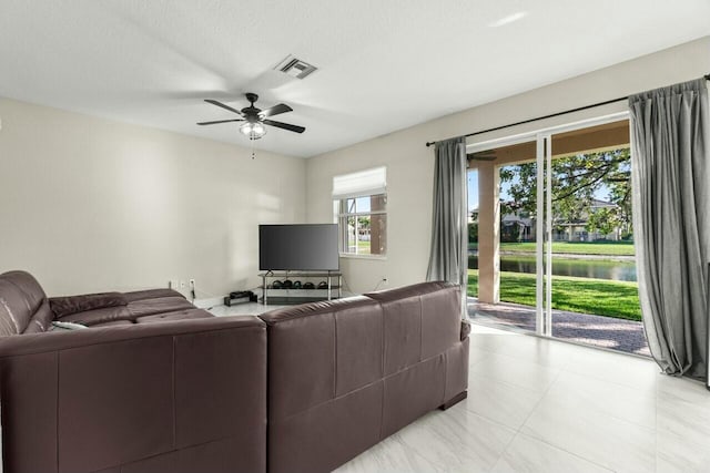 living room with a textured ceiling and ceiling fan