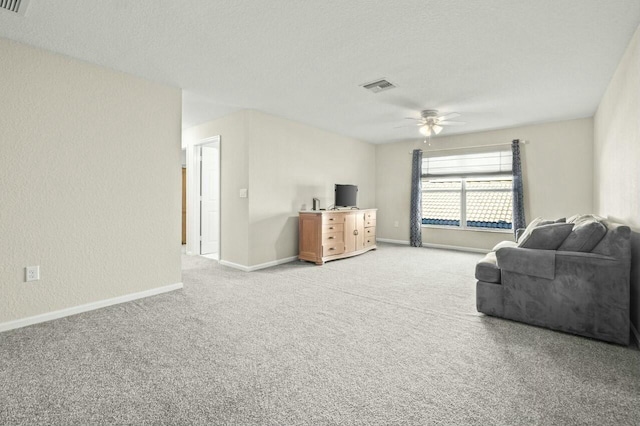 carpeted living room with a textured ceiling and ceiling fan