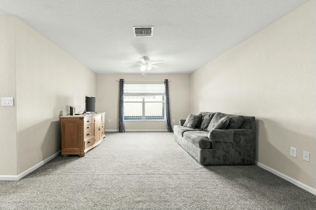 living room featuring carpet, a textured ceiling, and ceiling fan