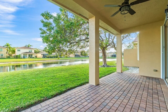 view of patio / terrace featuring a water view and ceiling fan