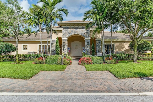 mediterranean / spanish home with a front yard