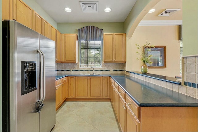 kitchen with sink, light tile patterned floors, stainless steel refrigerator with ice dispenser, tasteful backsplash, and kitchen peninsula