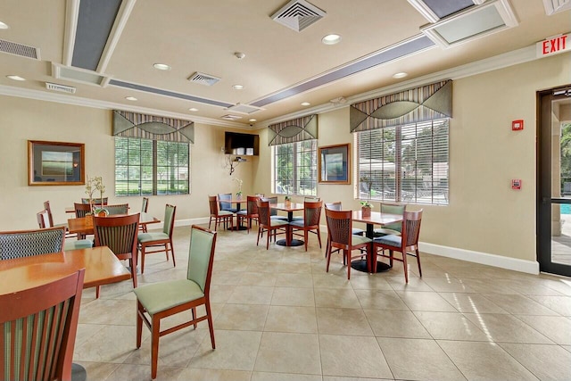 dining area featuring a tray ceiling, light tile patterned floors, and crown molding