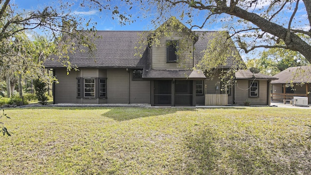 rear view of house with a sunroom and a lawn