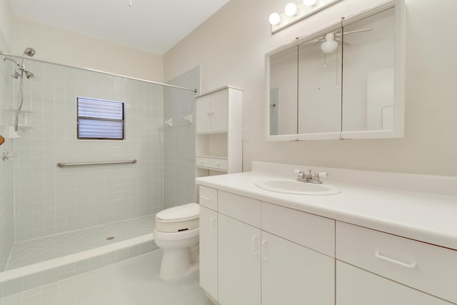 bathroom with vanity, tile patterned floors, toilet, and tiled shower