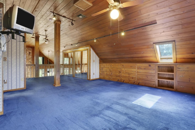 bonus room with wooden walls, lofted ceiling with skylight, dark carpet, and wooden ceiling